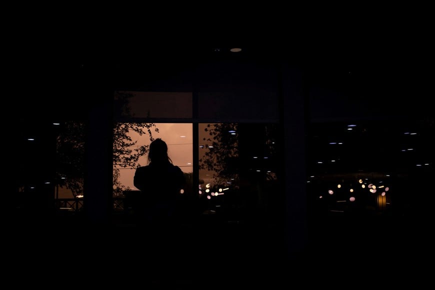 A woman looks at wind, rain, and flying debris from a hotel lobby during a power outage ahead of the arrival of Hurricane Isaias, in Pensacola, Florida, US, October 9, 2026. REUTERS/Marco Bello