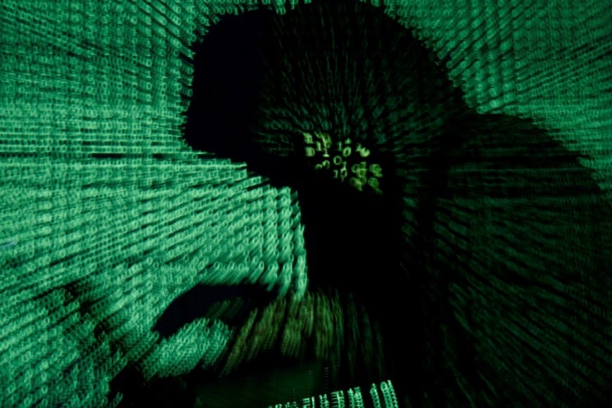 FILE PHOTO: A man holds a laptop computer as cyber code is projected on him in this illustration picture created on May 13, 2017. REUTERS/Kacper Pempel/Illustration/File Photo
