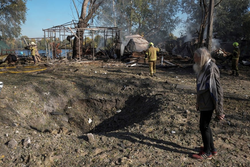 A resident looks at a crater that appeared at the site of an open-air restaurant after a Russian missile strike, amid Russia's attack on Ukraine, in Kyiv, Ukraine October 10, 2026. REUTERS/Andrii Khodkov