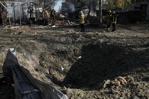 Firefighters work next to a crater that appeared at the site of an open-air restaurant after a Russian missile strike, amid Russia's attack on Ukraine, in Kyiv, Ukraine, October 10, 2026. REUTERS/Andrii Khodkov