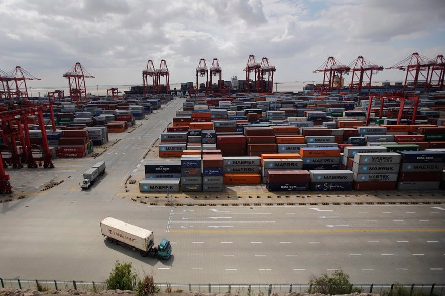 Container trucks drive past the container area at the Yangshan Deep Water Port, part of the newly announced Shanghai Free Trade Zone, south of Shanghai September 26, 2013. China has formally announced detailed plans for a new free-trade zone (FTZ) in Shanghai, touted as the country's biggest potential economic reform since Deng Xiaoping used a similar zone in Shenzhen to pry open a closed economy to trade in 1978. In an announcement on Friday from the State Council, or cabinet, China said it will open up its largely sheltered services sector to foreign competition in the zone and use it as a testbed for bold financial reforms, including a convertible yuan and liberalized interest rates. Economists consider both areas key levers for restructuring the world's second-largest economy and putting it on a more sustainable growth path. Picture taken on September 26, 2013. REUTERS/Carlos Barria (CHINA - Tags: POLITICS BUSINESS INDUSTRIAL) china shanghai china puerto de aguas profundas Yangshan puertos