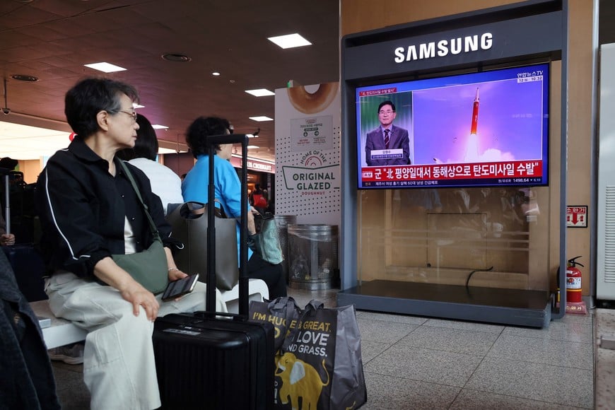 People watch a TV broadcasting a news report on North Korea firing multiple ballistic missiles toward the sea off its east coast, at a railway station in Seoul, South Korea, October 12, 2026. REUTERS/Kim Hong-Ji