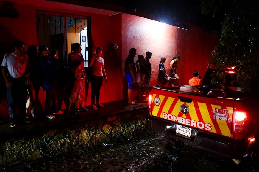 People, standing near an emergency vehicle, watch as the authorities assess whether the area needs to be evacuated as Hurricane Simon approaches Mexico's Pacific coast in Costalegre, Jalisco state, Mexico, October 11, 2026. REUTERS/Daniel Becerril