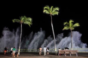 People watch waves crash against the waterfront promenade as Hurricane Simon approaches Mexico's Pacific coast in Puerto Vallarta, Mexico, October 11, 2026. REUTERS/Christian Ruano TPX IMAGES OF THE DAY