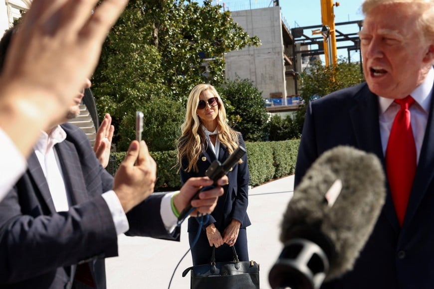 New White House Press Secretary Katie Zacharia listens to US President Donald Trump speaking to the media as he departs the White House in Washington, DC, US, October 13, 2026. REUTERS/Kevin Lamarque