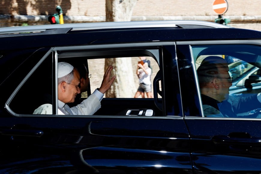 Pope Leo waves from a car window as he leaves the Vatican, ahead of his hospitalization for surgery to remove a lung nodule, in Rome, Italy, October 13, 2026. REUTERS/Remo Casilli