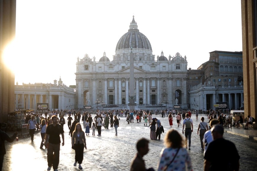 People walk in front of St. Peter's Basilica as Pope Leo recovers in hospital following lung surgery and cancer diagnosis, in Rome, Italy, October 14, 2026. REUTERS/Stoyan Nenov