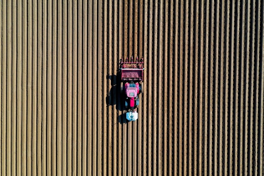 A farmer drives a tractor in his field while planting potatoes in Tilloy-lez-Cambrai, near Cambrai, France, April 18, 2021. Picture taken with a drone. REUTERS/Pascal Rossignol TPX IMAGES OF THE DAY