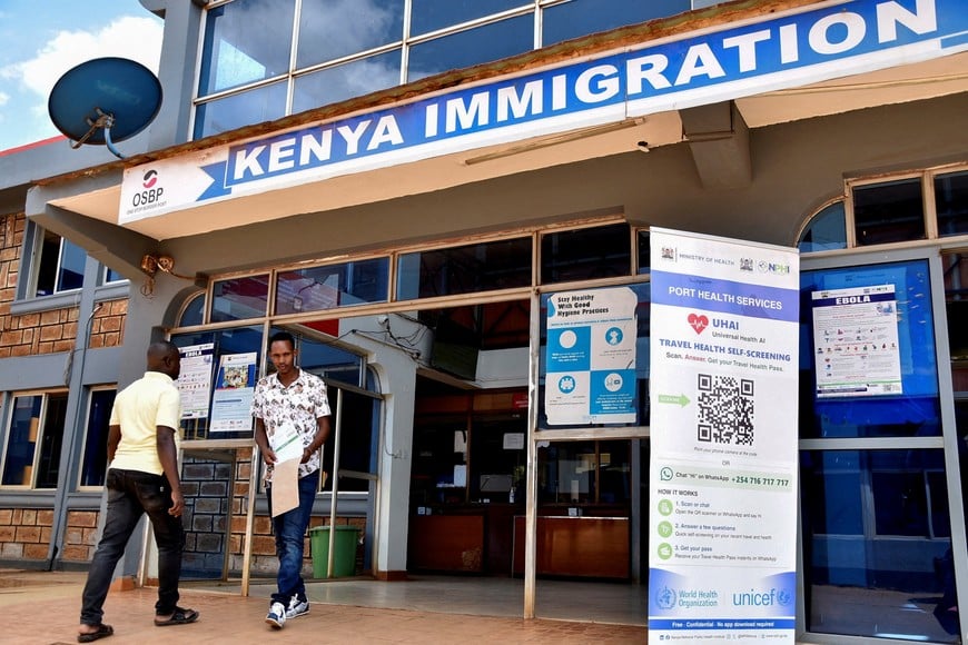 FILE PHOTO: Travellers walk at the Kenya immigration services to access port health services at the Busia One Stop Border Post, crossing-point between Kenya and Uganda, after a man who had been living in the Democratic Republic of Congo travelled and died of a new Ebola outbreak involving the Bundibugyo species at the Nairobi Hospital, in Busia, Kenya October 8, 2026. REUTERS/James Keyi/File Photo