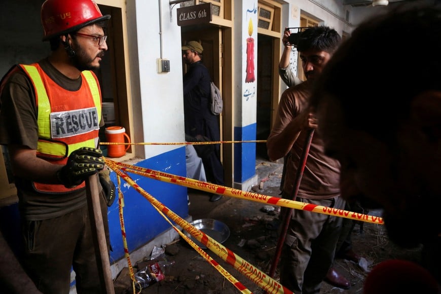 A rescue worker cordons an area after a school roof collapse in Peshawar, Pakistan, October 15, 2026. REUTERS