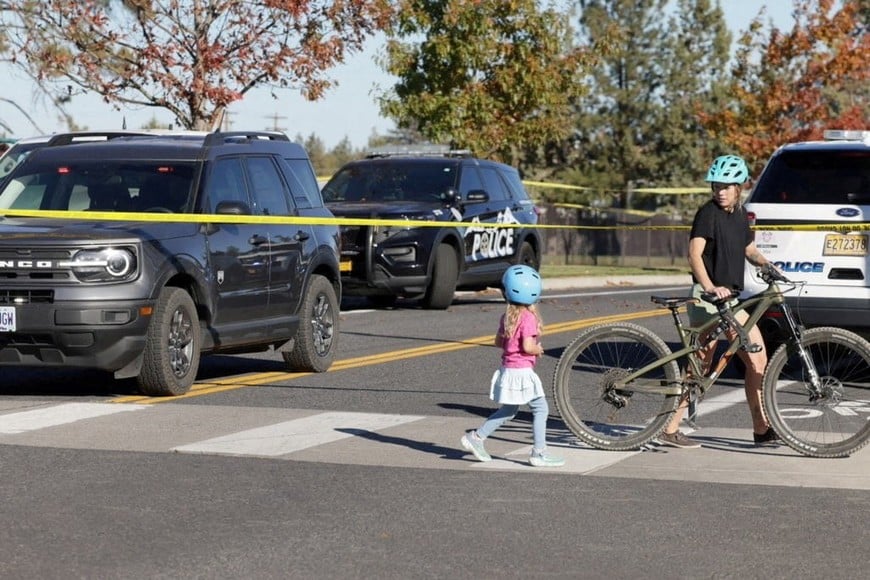 A child walks near police tape following a shooting at Silver Rail Elementary School in Bend, Oregon, US, October 15, 2026. REUTERS/Rob Kerr TPX IMAGES OF THE DAY