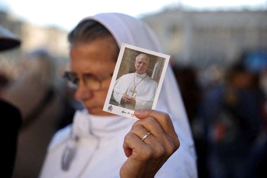 A person holds a picture of Pope Leo on the day of a mass marking the 10th anniversary of the apostolic exhortation Amoris Laetitia, including special prayers for the health of Pope Leo, who is in a hospital after lung surgery, in St. Peter's Square at the Vatican, October 14, 2026. REUTERS/Stoyan Nenov TPX IMAGES OF THE DAY