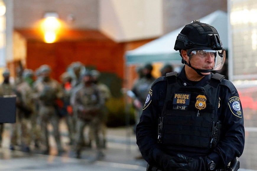 FILE PHOTO: A Federal Protective Service police officer guards the gate of a ICE facility in Portland, Oregon, U.S. October 26, 2025. REUTERS/John Rudoff/File Photo
