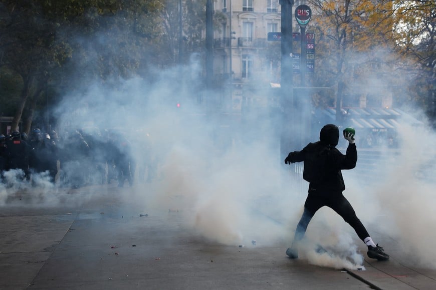 A protester throws a projectile through tear gas amid clashes with the French riot police at the Place de la Republique during a demonstration against the cost of living and rising fuel prices in Paris as part of nationwide protests called by the "Yellow Vests" movement, joined by French high school and university students, teachers and parents demanding better school conditions and government action, as well as labour unions, workers, farmers and retirees, France, October 17, 2026. REUTERS/Stephanie Lecocq