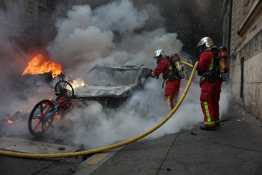 French firefighters work to extinguish burning car amid clashes during a day of demonstrations against the cost of living and rising fuel prices in Paris as part of nationwide protests called by the "Yellow Vests" movement, joined by French high school and university students, teachers and parents demanding better school conditions and government action, as well as labour unions, workers, farmers and retirees, France, October 17, 2026. REUTERS/Stephanie Lecocq