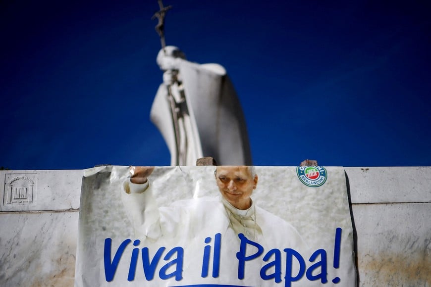 A message of support for Pope Leo, near a statue of Pope John Paul II, outside Gemelli Hospital, after Vatican said Pope Leo is showing steady improvement and will make his first public appearance since his hospitalisation on Sunday to deliver the traditional Angelus, after he was diagnosed with lung cancer, after surgeons removed a part of his right lung, in Rome, Italy, October 16, 2026. REUTERS/Guglielmo Mangiapane      TPX IMAGES OF THE DAY