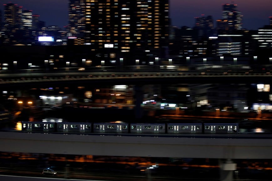 A Yurikamome line train, a driverless automatic train system, travels past buildings in Tokyo, Japan, April 21, 2021. Picture taken with a slow shutter speed. REUTERS/Kim Kyung-Hoon SEARCH "TOKYO POSTCARDS" FOR THIS STORY. SEARCH "WIDER IMAGE" FOR ALL STORIES