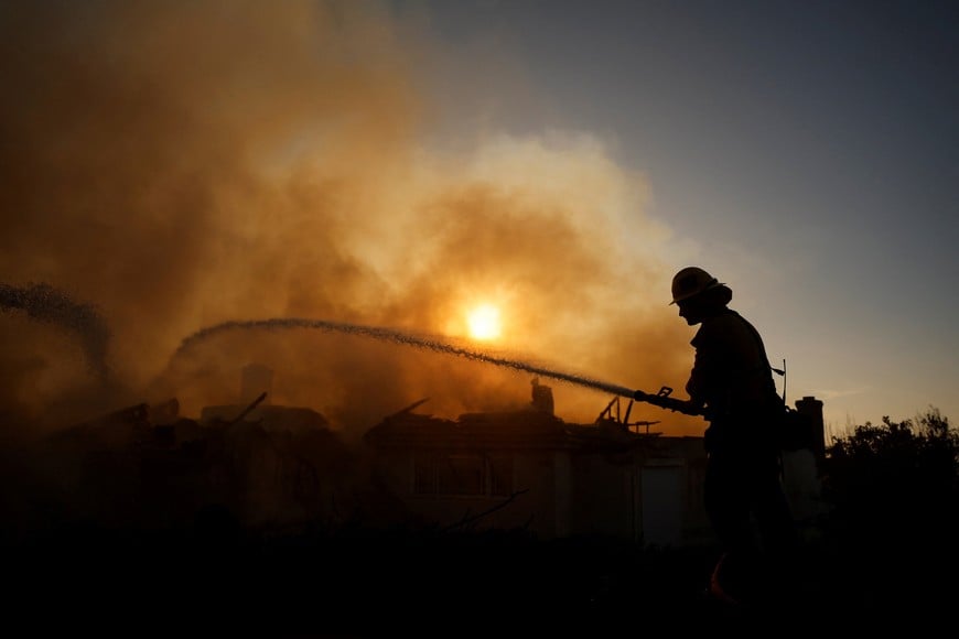 A firefighter uses a water hose to battle the Norte Fire as wildfires rage in San Clemente, California, US, October 16, 2026. REUTERS/Caroline Brehman