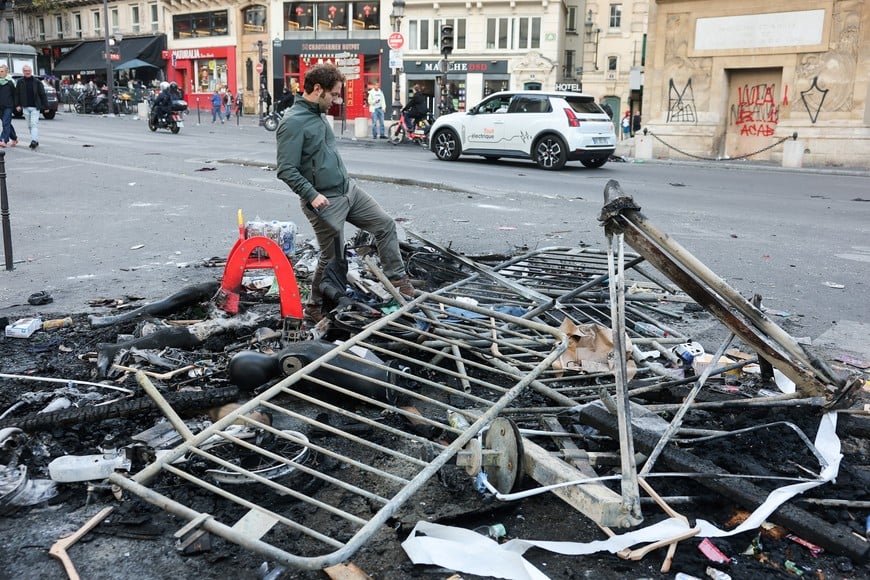 A person walks on debris, the day after clashes during a national day of demonstrations against the cost of living and rising fuel prices, in Paris, France, October 18, 2026. REUTERS/Stephanie Lecocq