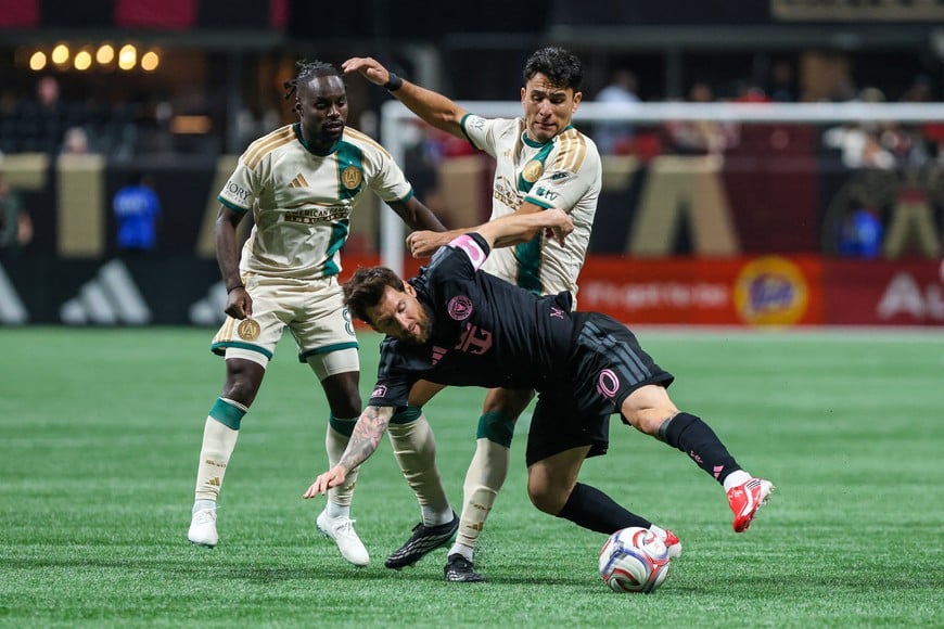 Oct 17, 2026; Atlanta, Georgia, USA; Inter Miami CF forward Leo Messi (10) falls while defending the ball against Atlanta United midfielder Tristan Muyumba (8) and defender Junior Alonso (6) during the second half at Mercedes-Benz Stadium. Mandatory Credit: Jordan Godfree-Imagn Images