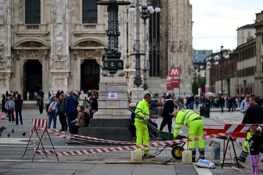 Municipal workers carry out work in Piazza Duomo, a day after clashes between police and protesters during demonstrations over rising living costs and poor public services, in Milan, Italy, October 19, 2026. REUTERS/Daniele Mascolo