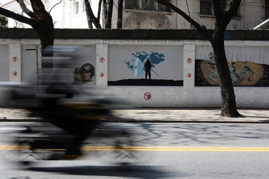 A motorcyclist rides past murals depicting soldiers and a map of the Falkland Islands, known in Argentina as the Islas Malvinas, commemorating the 1982 war between Britain and Argentina over the Falklands, in Buenos Aires, Argentina, September 15, 2026. REUTERS/Alessia Maccioni