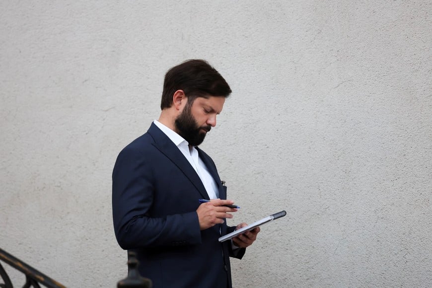 Chile's President Gabriel Boric checks a notebook as he walks downstairs after a meeting with President-elect Jose Antonio Kast at La Moneda Presidential Palace in Santiago, Chile, March 3, 2026. REUTERS/Pablo Sanhueza