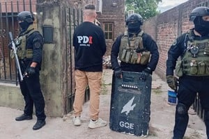 Efectivos con equipamiento táctico de protección resguardan el ingreso a una propiedad allanada en el norte de la ciudad.