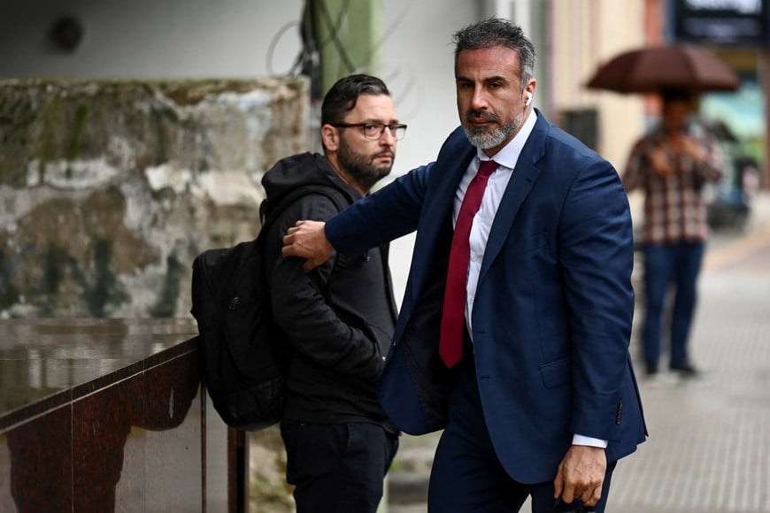 Leopoldo Luque, personal doctor for late Argentine soccer legend Diego Maradona, walks past Mariano Perroni, nursing coordinator for Maradona, as he arrives at the San Isidro court before a hearing concluding the closing-argument phase of Maradona's death trial, in San Isidro, on the outskirts of Buenos Aires, Argentina, October 21, 2026. REUTERS/Pedro Lazaro Fernandez
