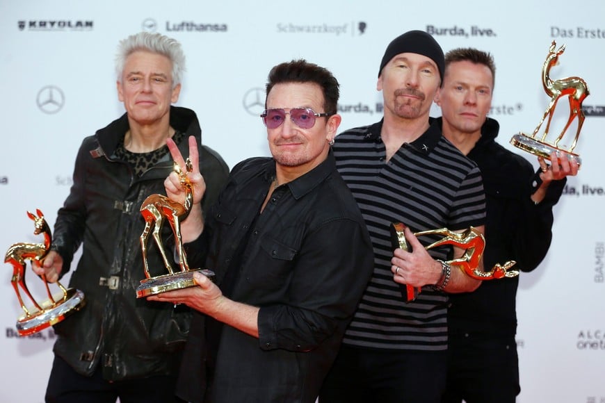 Adam Clayton, Bono, the Edge and Larry Mullen (L-R) of the band U2 pose with their Music International trophies during the Bambi 2014 media awards ceremony in Berlin in this November 13, 2014 file photo. Irish rock band U2 set early December dates for concerts in Paris on November 23, 2015, after cancelling two earlier performances following the attacks by Islamic State militants that took 130 lives.     REUTERS/Hannibal Hanschke/Files berlin alemania Adam Clayton Bono Larry Mullen the Edge grupo banda udos u2 musica musico musicos cantante premios para los medios Bambi 2014