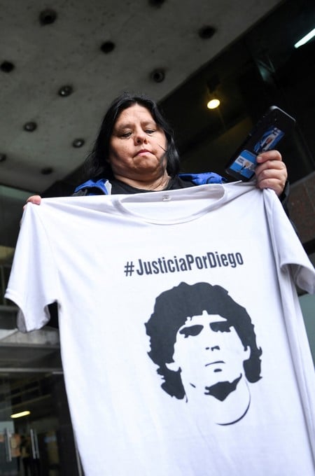 A person holds a T-shirt depicting late Argentine soccer legend Diego Maradona and bearing the words "Justice for Diego" outside the San Isidro court on the day of a hearing concluding the closing-argument phase of Maradona's death trial, in San Isidro, on the outskirts of Buenos Aires, Argentina, October 21, 2026. REUTERS/Pedro Lazaro Fernandez
