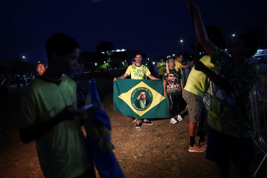 Supporters of Brazilian presidential candidate Flavio Bolsonaro of the Liberal Party (PL) attend an event on the street, waiting for the first results of the presidential runoff election, in Brasilia, Brazil, October 25, 2026. REUTERS/Agustin Marcarian