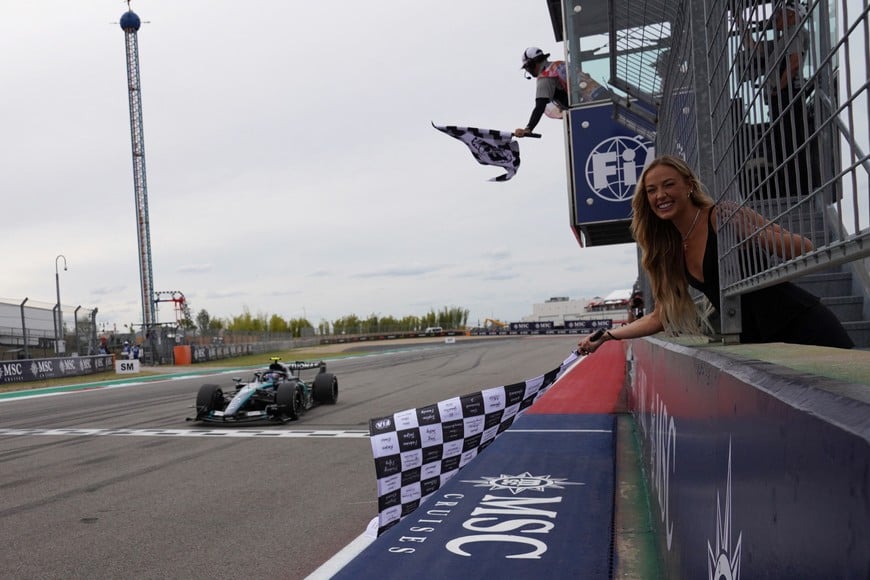 Formula One F1 - United States Grand Prix - Circuit of the Americas, Austin, Texas, U.S. - October 25, 2026
Basketball player Sophie Cunningham waves the checkered flag as Mercedes' Andrea Kimi Antonelli crosses the finish line to win the United States Grand Prix Pool via REUTERS/Dustin Safranek