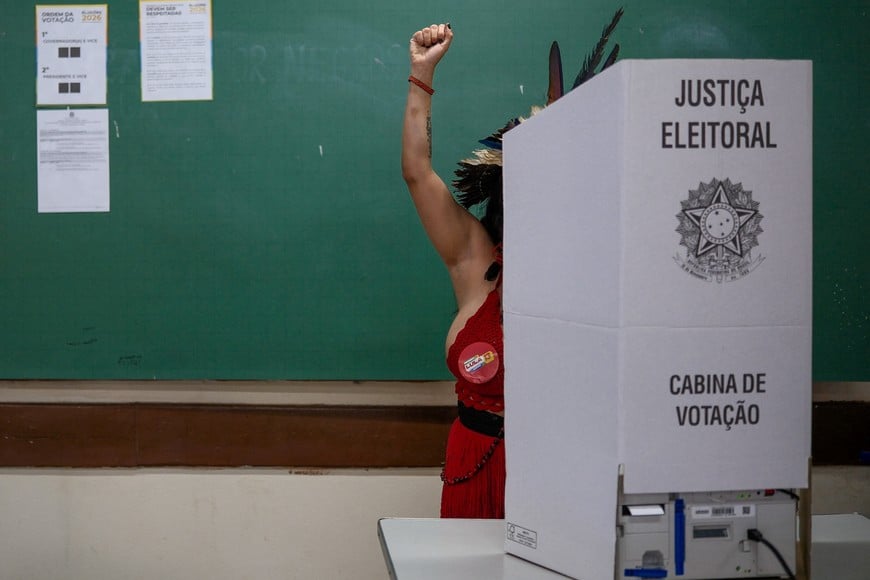 Indigenous woman Ramona Juca, 27, a supporter of Brazilian President Luiz Inacio Lula da Silva, the Workers' Party (PT) candidate for presidential re-election, raises her fist as she votes at a polling station during the Brazilian presidential runoff election, on the outskirts of Brasilia, Brazil, October 25, 2026. REUTERS/Diego Herculano TPX IMAGES OF THE DAY