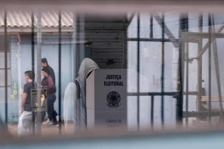 A person stands at a voting booth during the Brazilian presidential runoff election, in Porto Alegre, Brazil October 25, 2026. REUTERS/Diego Vara