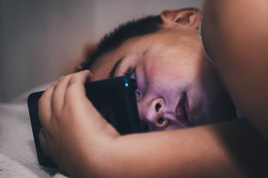 joven cama celular pantallas