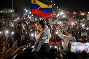 Venezuelan opposition leader Maria Corina Machado carries a girl as she greets supporters along a highway after returning to Venezuela following nearly a year abroad, in Maracay, Venezuela, October 25, 2026. REUTERS/Gaby Oraa     TPX IMAGES OF THE DAY
