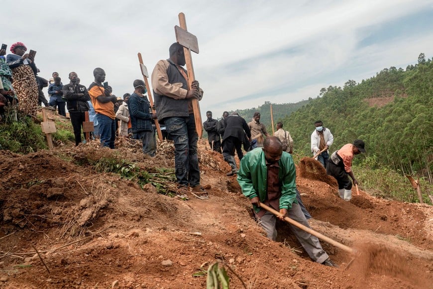 FILE PHOTO: Relatives attend the funeral of an eight-month pregnant Congolese woman, who died of Ebola, and her fetus, at a cemetery, as aid agencies intensify efforts to contain a new Ebola outbreak involving the Bundibugyo species, in Butembo, North Kivu province, Democratic Republic of Congo, October 5, 2026. REUTERS/Gradel Muyisa Mumbere/File Photo