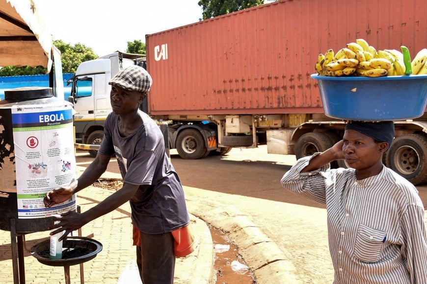 A fruit vendor carries bananas as she walks at the Busia One Stop Border Post, crossing-point between Kenya and Uganda, after a man who had been living in the Democratic Republic of Congo travelled and died of a new Ebola outbreak involving the Bundibugyo species at the Nairobi Hospital, in Busia, Kenya October 8, 2026. REUTERS/James Keyi TPX IMAGES OF THE DAY