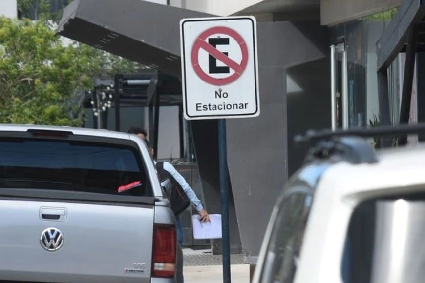 Dos coches estacionados frente a un cartel que dice: “No estacionar”. Créditos: Guillermo Di Salvatore