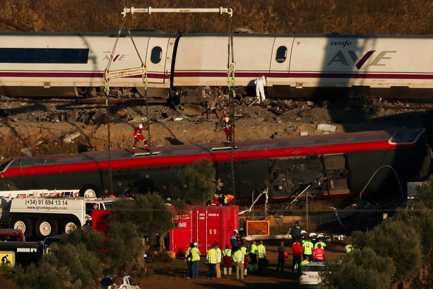 Emergency personnel and investigators work as cranes are used at the site of the collision the day after two high-speed trains crashed between the towns of Mora and Orgaz, near Toledo, Spain, October 29, 2026. REUTERS/Susana Vera