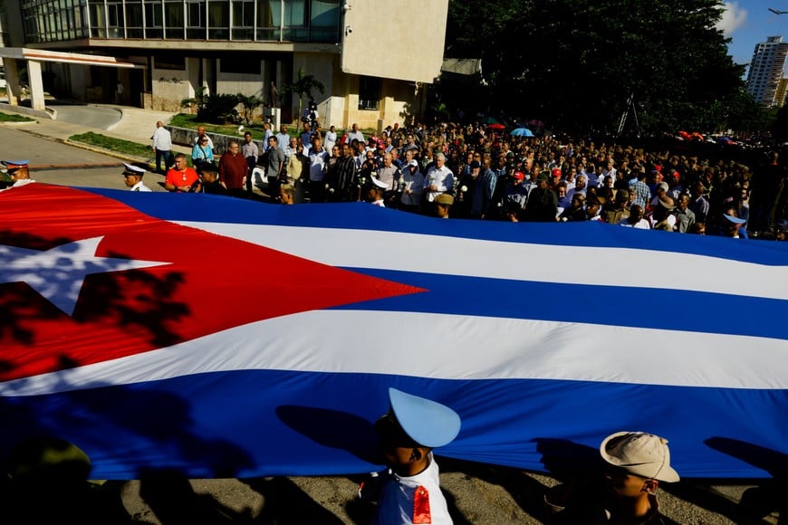 People carry a Cuban flag during a ceremony to honor late rebel hero Camilo Cienfuegos, who went missing during a flight on this day in 1959, in Havana, Cuba, October 28, 2026 REUTERS/Norlys Perez