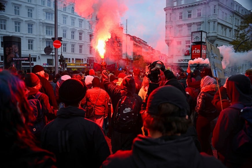 A person lights a flare during a nationwide protest by campaign group Gen Z regelt (Gen Z takes charge) against underfunding of schools, cuts to education, social services, culture and healthcare, rising living costs, and military conscription, in Hamburg, Germany, October 31, 2026. REUTERS/Jonas Walzberg