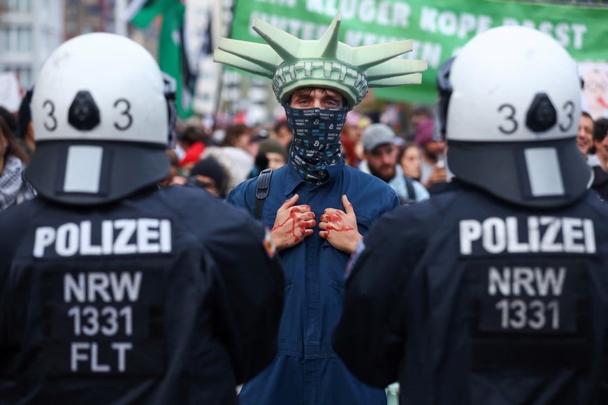 A protester stands next to police officers during a nationwide protest by campaign group Gen Z regelt (Gen Z takes charge) against underfunding of schools, cuts to education, social services, culture and healthcare, rising living costs, and military conscription, in Cologne, Germany, October 31, 2026. REUTERS/Thilo Schmuelgen TPX IMAGES OF THE DAY