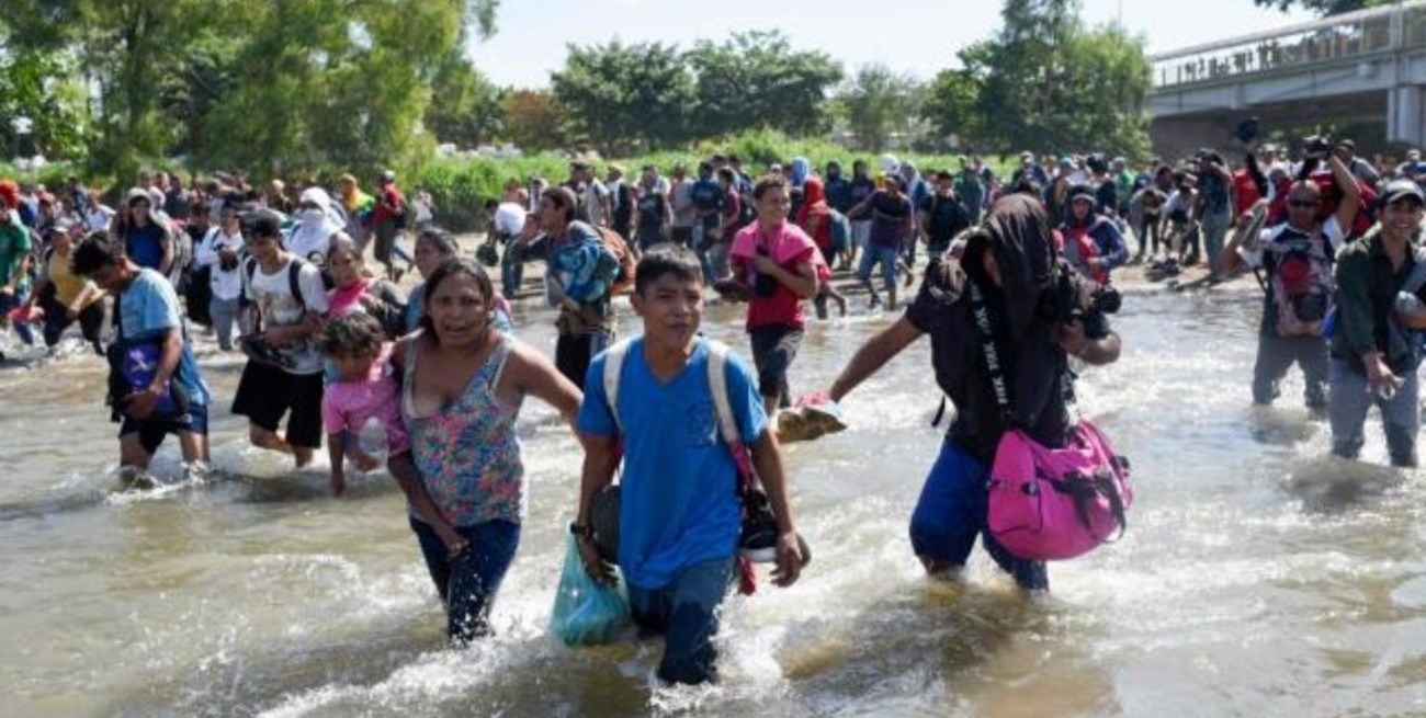 Una ola de migrantes cruza de Guatemala a México a través de un río