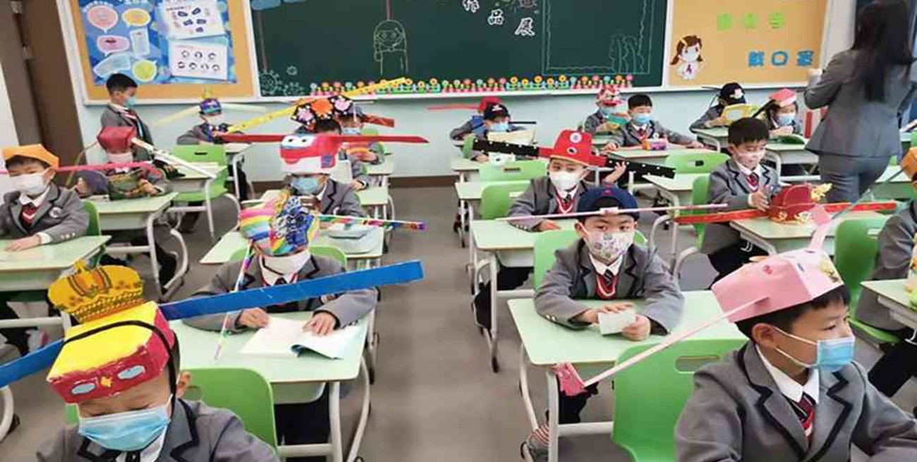 China: niños regresan a clases con sombreros de un metro para mantener la distancia social