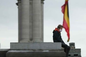 Xinhua Un hombre que porta una mascarilla reposa en el Parque del Cincuentenario, en Bélgica, luego de que se informaran estrictas reglas de confinamiento para combatir la Covid-19.