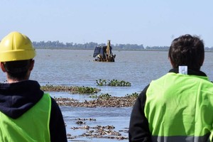 Con varios centímetros más de agua, la retroexcavadora llegó hasta el punto demarcado para que se haga la inserción de los caños. Crédito: Guillermo Di Salvatore