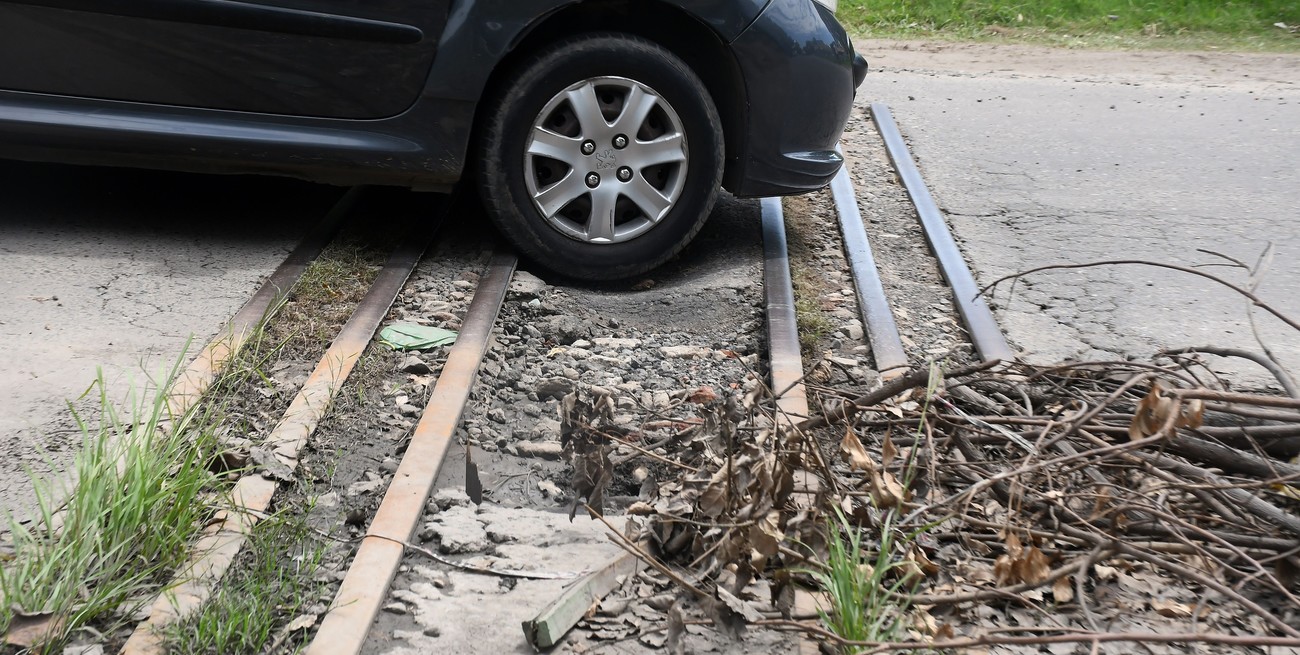 Vecinos ponen ramas para anunciar un pozo sobre las vías del fallido Tren Urbano