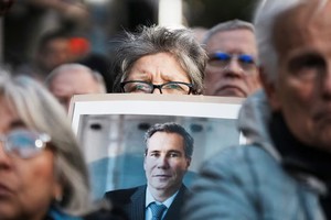 Una manifestante sostiene un cartel con la foto del fallecido fiscal Alberto Nisman.